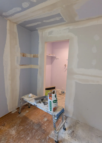 Drywall finishing in progress — taping and mudding walls