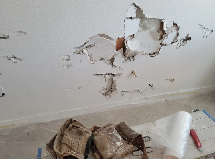 Large drywall hole damage before repair